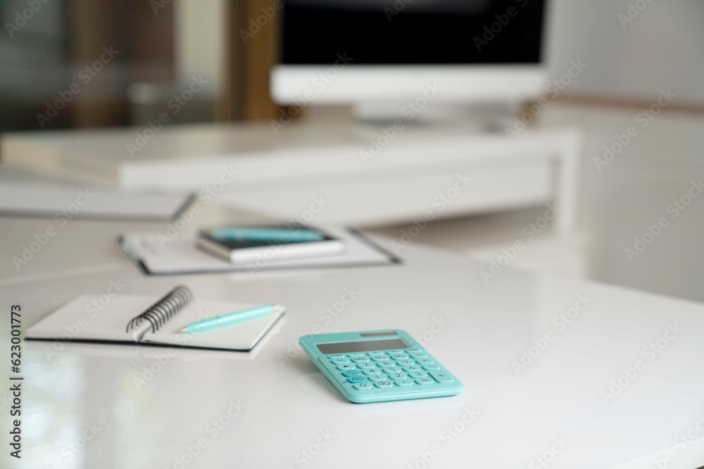 Workplace in the office. Notebook, computer, mobil phone and calculator on the white shining desk. Workplace in the office. Notebook, computer, mobil phone and calculator on the white shining desk.