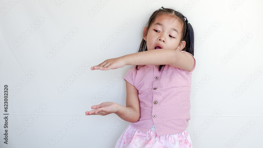 Beautiful smiling happy little asian girl in pink shirt. Charming female child open hands palm up holding something on isolated white background. Adorable pretty child and copy space.