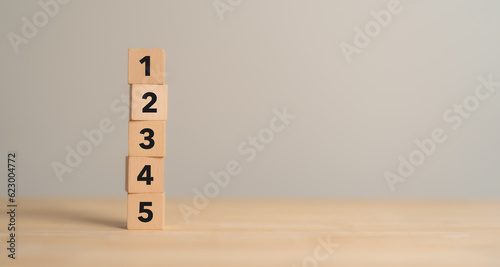 Task priority and management concept. The order of priority in any activity. Set work priority, arrange to do list. Wooden cube blocks with number first, second, third, fourth and fifth.