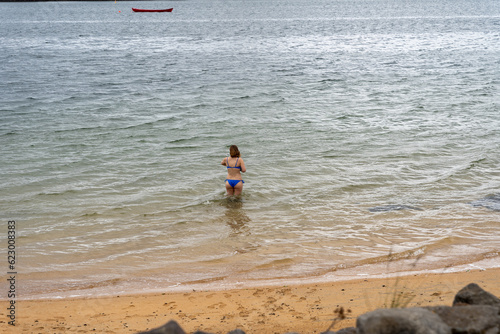 Caucasian woman in bikini going in water at Nautholsvik Beach in Reykjavik, Iceland photo