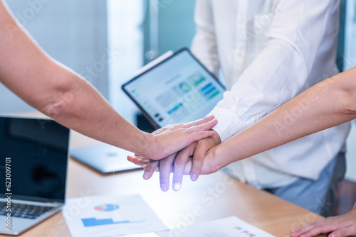 Employees working together to achieve the set goals with graph data and holding a tablet for meetings.Membership togetherness partnership and success Concept photo