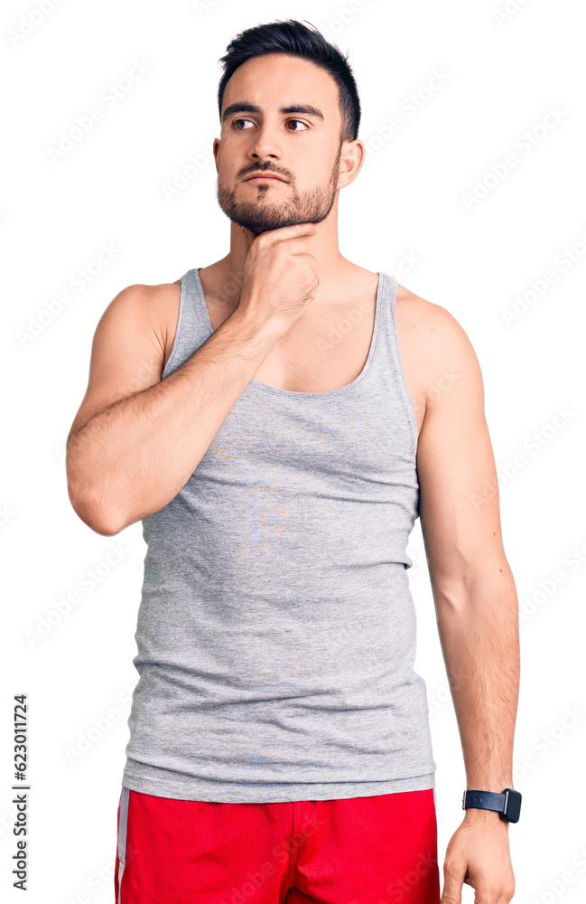 Young handsome man wearing swimwear and sleeveless t-shirt touching painful neck, sore throat for flu, clod and infection Young handsome man wearing swimwear and sleeveless t-shirt touching painful neck, sore throat for flu, clod and infection