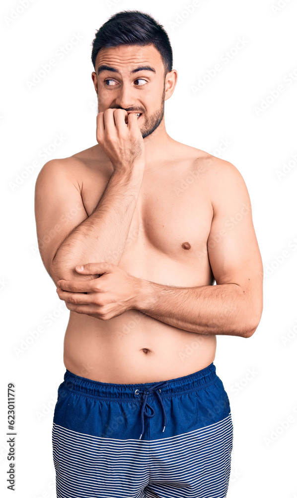 Fototapeta premium Young handsome man wearing swimwear looking stressed and nervous with hands on mouth biting nails. anxiety problem.