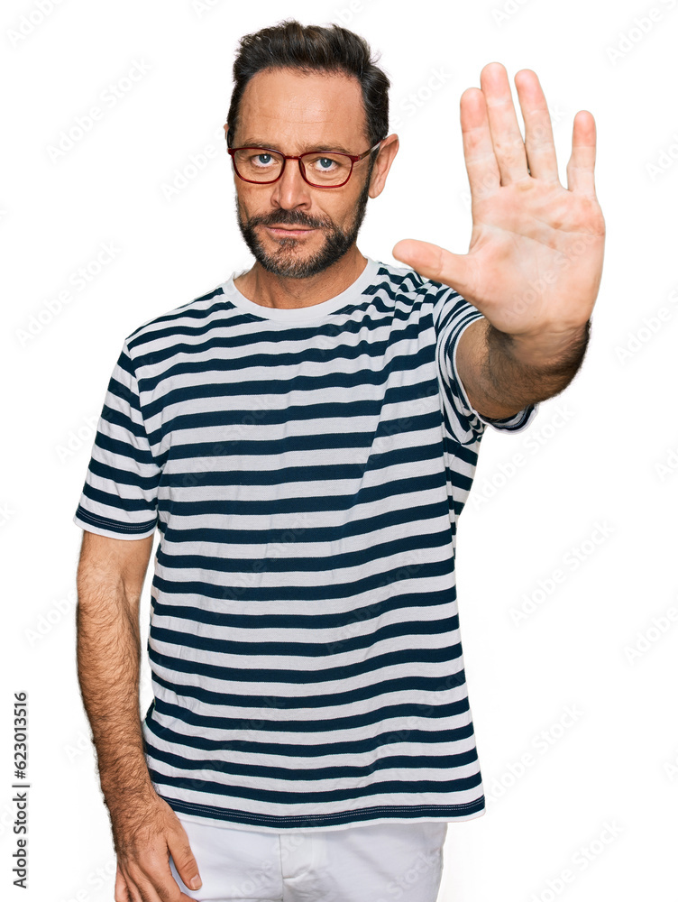 Middle age man wearing casual clothes and glasses doing stop sing with palm of the hand. warning expression with negative and serious gesture on the face. Middle age man wearing casual clothes and glasses doing stop sing with palm of the hand. warning expression with negative and serious gesture on the face.