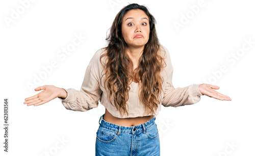 Young hispanic girl wearing casual clothes clueless and confused with open arms, no idea and doubtful face.