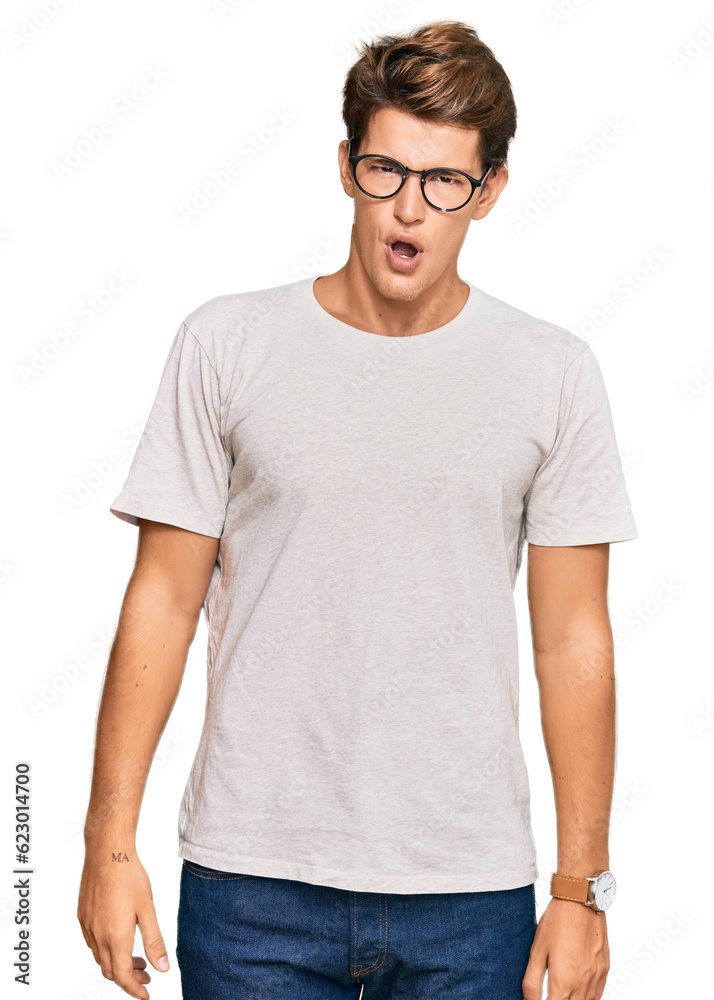 Handsome caucasian man wearing casual clothes and glasses in shock face, looking skeptical and sarcastic, surprised with open mouth Handsome caucasian man wearing casual clothes and glasses in shock face, looking skeptical and sarcastic, surprised with open mouth