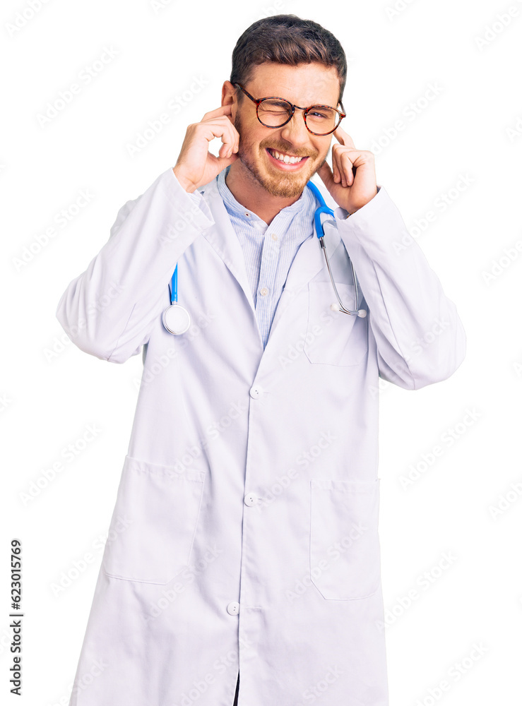 Handsome young man with bear wearing doctor uniform covering ears with fingers with annoyed expression for the noise of loud music. deaf concept. Handsome young man with bear wearing doctor uniform covering ears with fingers with annoyed expression for the noise of loud music. deaf concept.