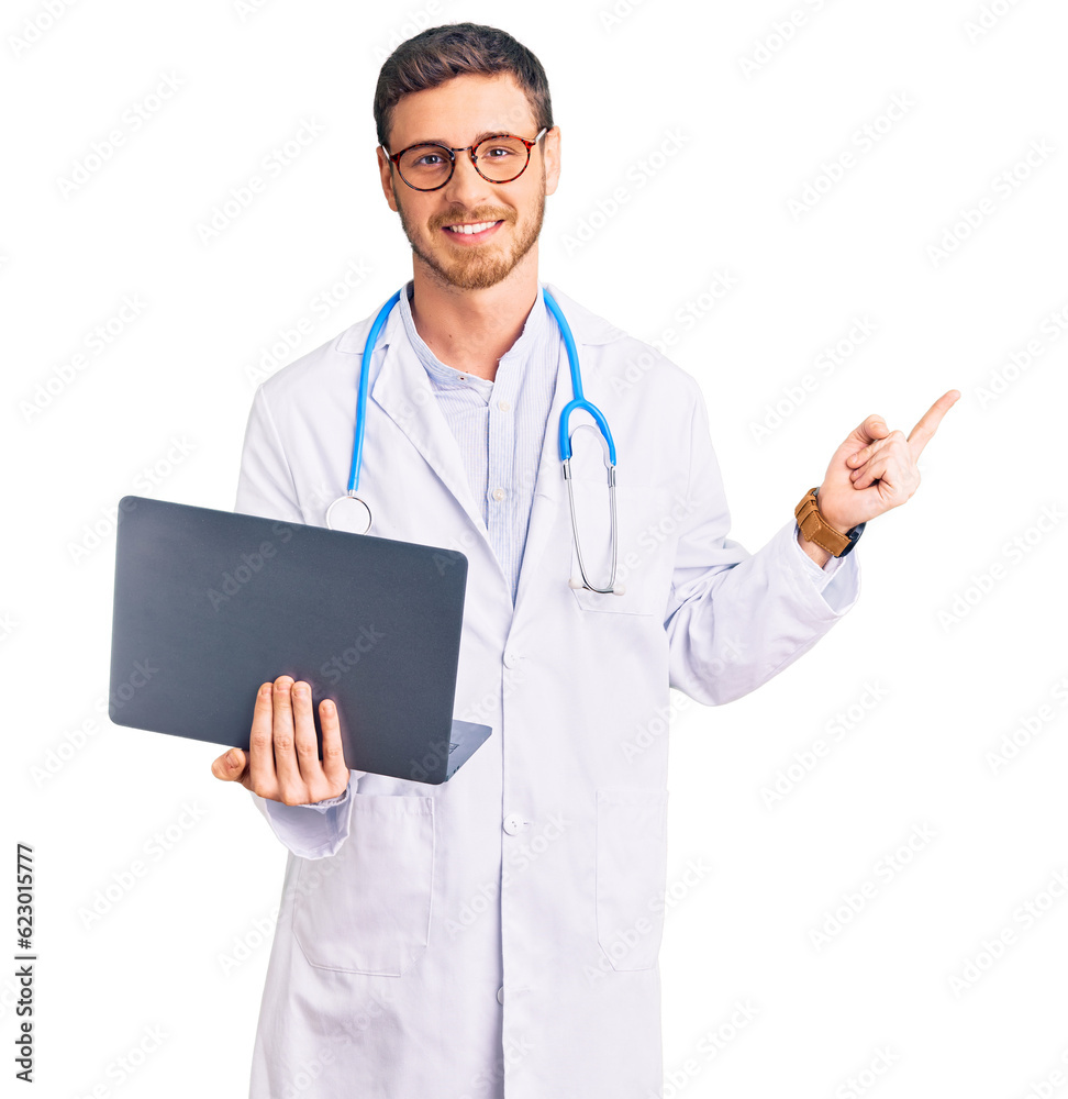 Handsome young man with bear wearing doctor uniform working using computer laptop smiling happy pointing with hand and finger to the side Handsome young man with bear wearing doctor uniform working using computer laptop smiling happy pointing with hand and finger to the side