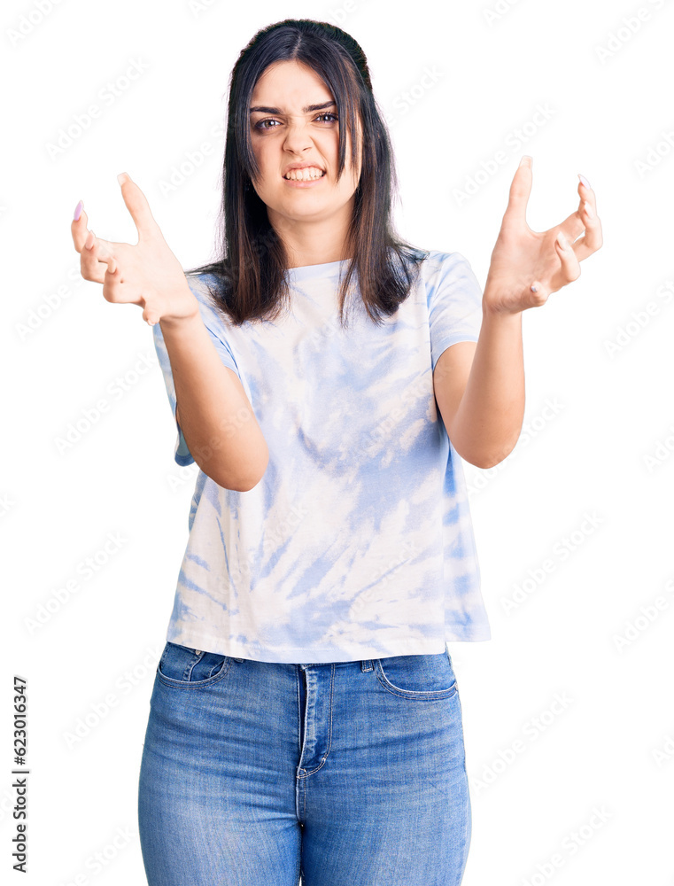 Young beautiful girl wearing casual t shirt shouting frustrated with rage, hands trying to strangle, yelling mad Young beautiful girl wearing casual t shirt shouting frustrated with rage, hands trying to strangle, yelling mad