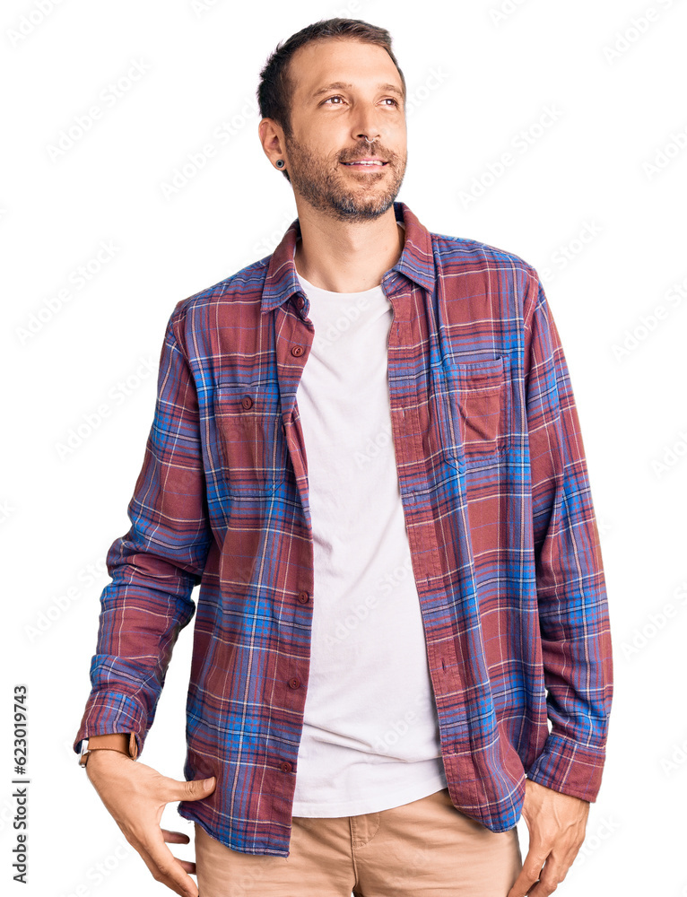 Young handsome man wearing casual clothes looking away to side with smile on face, natural expression. laughing confident. Young handsome man wearing casual clothes looking away to side with smile on face, natural expression. laughing confident.