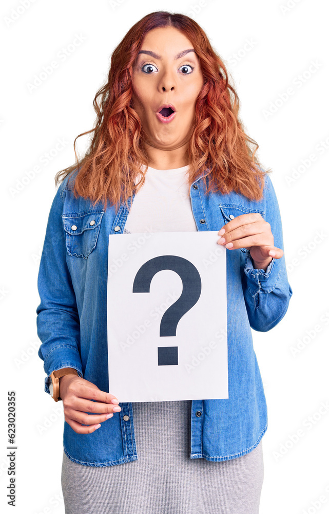 Young latin woman holding question mark scared and amazed with open mouth for surprise, disbelief face Young latin woman holding question mark scared and amazed with open mouth for surprise, disbelief face