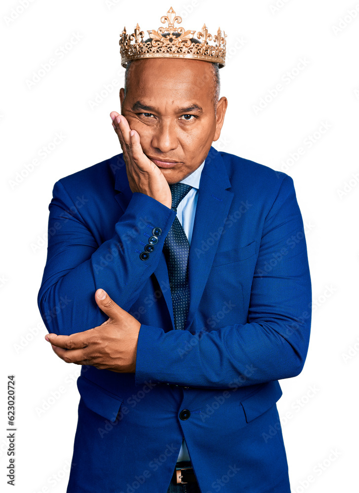 Hispanic middle age man wearing king crown thinking looking tired and bored with depression problems with crossed arms. Hispanic middle age man wearing king crown thinking looking tired and bored with depression problems with crossed arms.