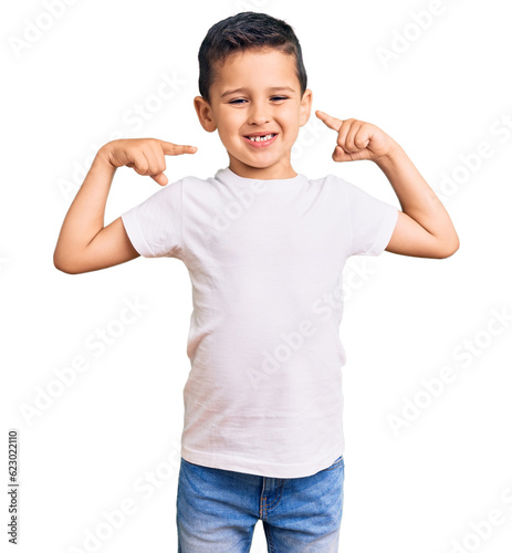 Little cute boy kid wearing casual white tshirt looking confident with smile on face, pointing oneself with fingers proud and happy.