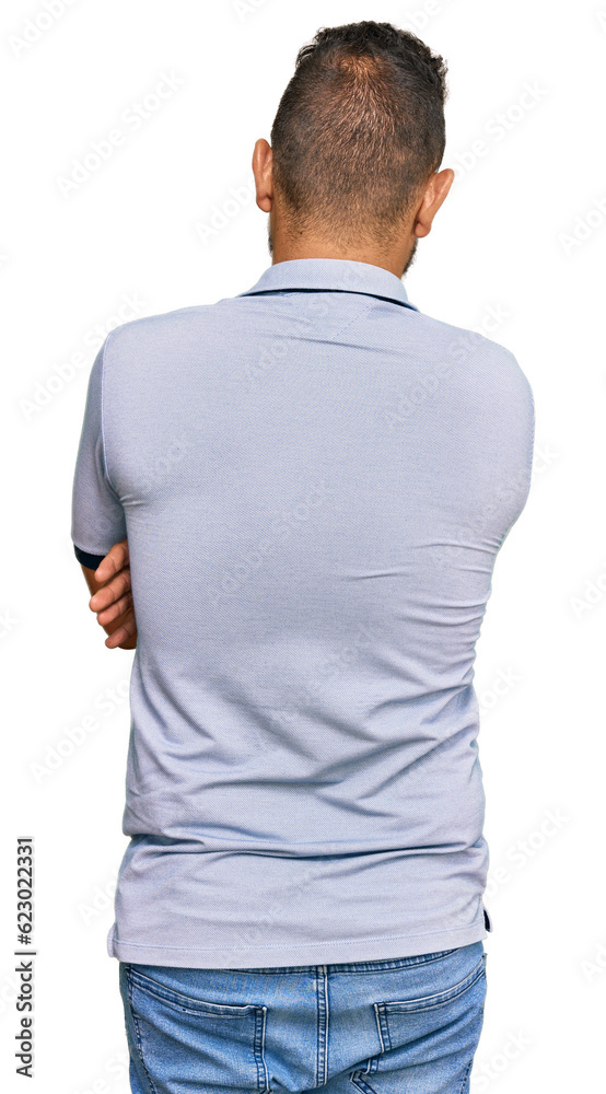 Handsome man with beard wearing casual clothes standing backwards looking away with crossed arms Handsome man with beard wearing casual clothes standing backwards looking away with crossed arms