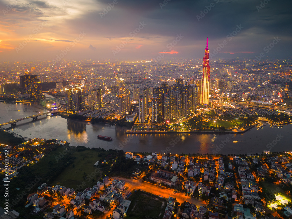 Obraz premium Aerial view of a Ho Chi Minh City, Vietnam with development buildings, transportation, energy power infrastructure. Financial and business centers. Sunset to night.