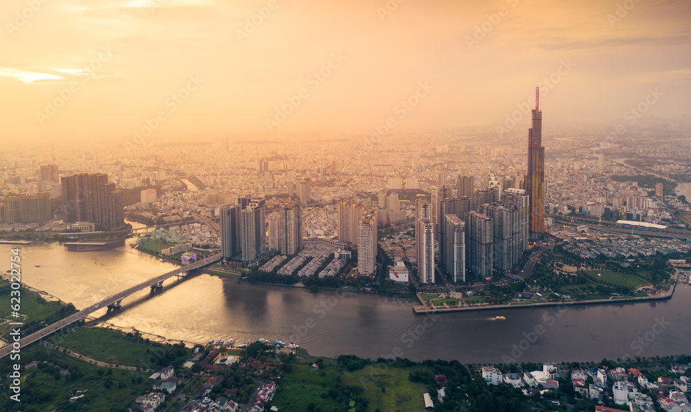 Naklejka premium Aerial view of a Ho Chi Minh City, Vietnam with development buildings, transportation, energy power infrastructure. Financial and business centers. Sunset to night.