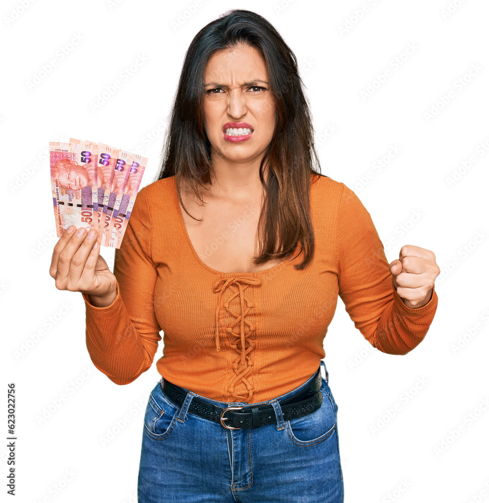 Beautiful hispanic woman holding south african 50 rand banknotes annoyed and frustrated shouting with anger, yelling crazy with anger and hand raised Beautiful hispanic woman holding south african 50 rand banknotes annoyed and frustrated shouting with anger, yelling crazy with anger and hand raised
