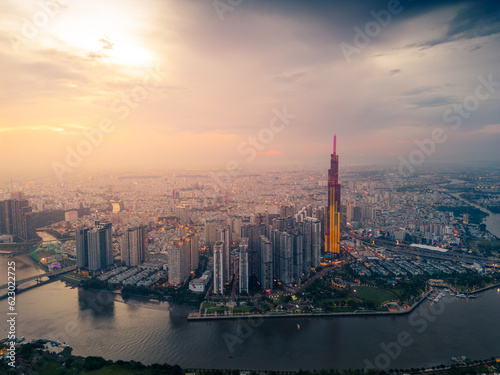 Aerial view of a Ho Chi Minh City, Vietnam with development buildings, transportation, energy power infrastructure. Financial and business centers. Sunset to night. © CravenA