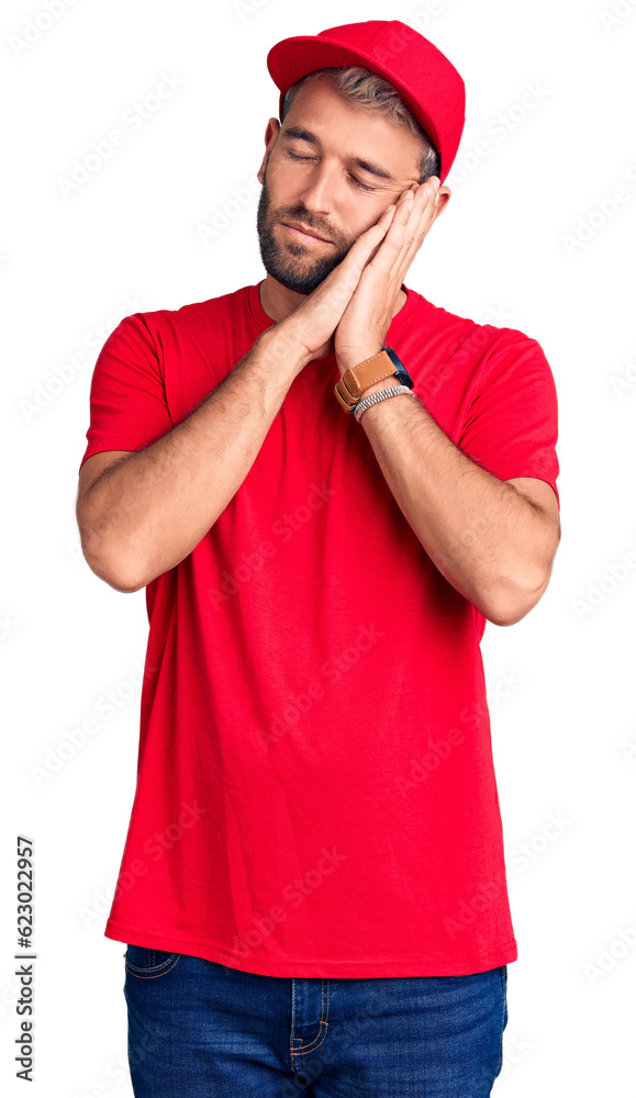 Young handsome blond man wearing t-shirt and cap sleeping tired dreaming and posing with hands together while smiling with closed eyes. Young handsome blond man wearing t-shirt and cap sleeping tired dreaming and posing with hands together while smiling with closed eyes.