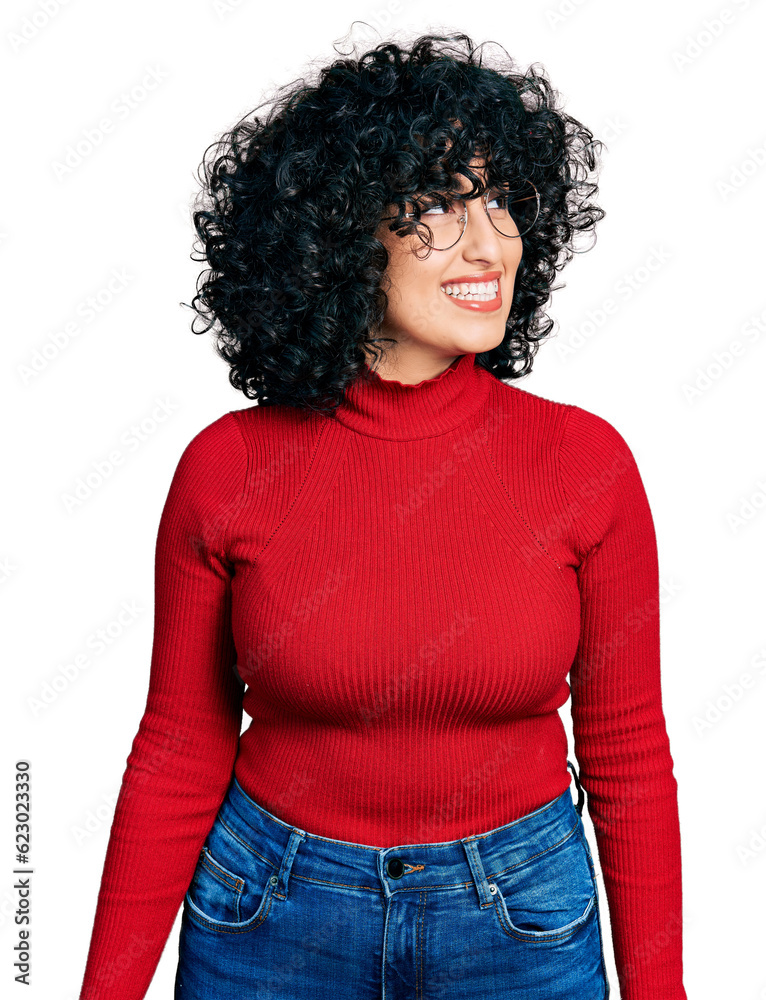 Young middle east girl wearing casual clothes and glasses looking away to side with smile on face, natural expression. laughing confident. Young middle east girl wearing casual clothes and glasses looking away to side with smile on face, natural expression. laughing confident.
