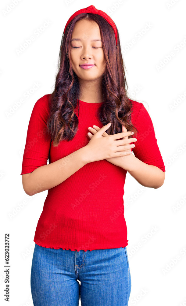 Naklejka premium Young beautiful chinese girl wearing casual clothes and diadem smiling with hands on chest with closed eyes and grateful gesture on face. health concept.
