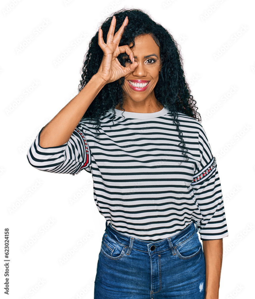Fototapeta premium Middle age african american woman wearing casual clothes doing ok gesture with hand smiling, eye looking through fingers with happy face.
