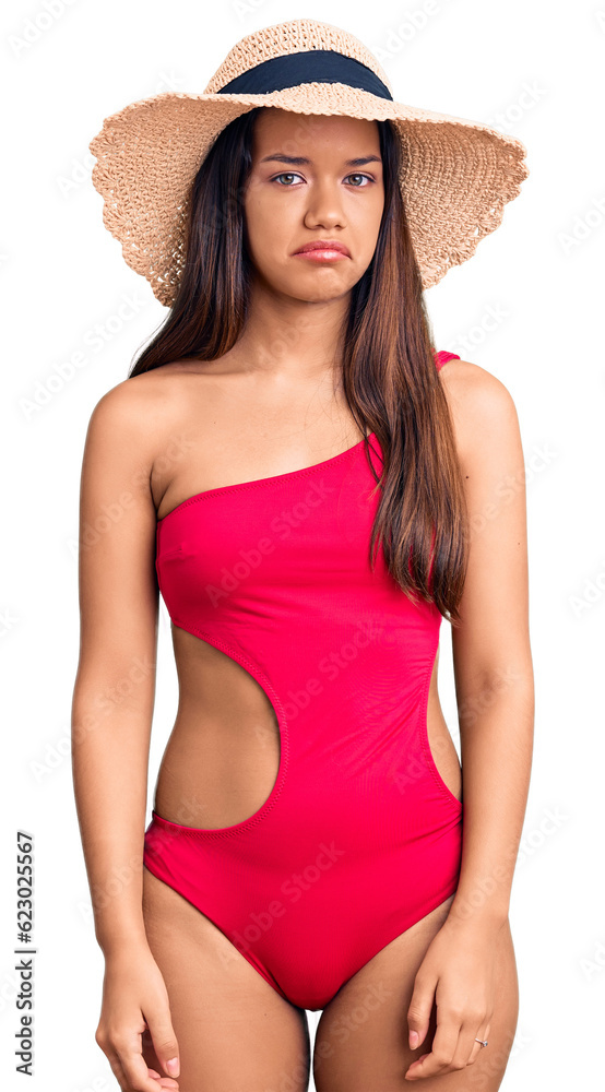 Young beautiful latin girl wearing swimwear and summer hat depressed and worry for distress, crying angry and afraid. sad expression. Young beautiful latin girl wearing swimwear and summer hat depressed and worry for distress, crying angry and afraid. sad expression.