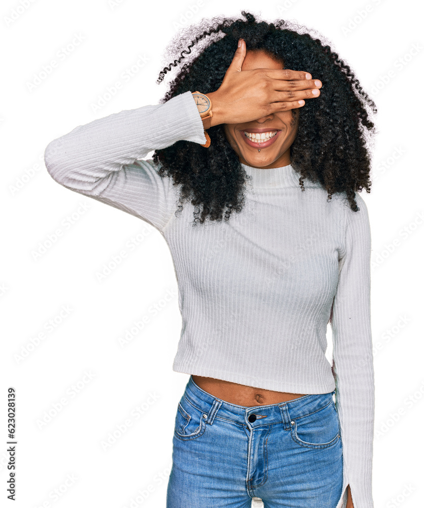 Young african american girl wearing casual clothes smiling and laughing with hand on face covering eyes for surprise. blind concept. Young african american girl wearing casual clothes smiling and laughing with hand on face covering eyes for surprise. blind concept.