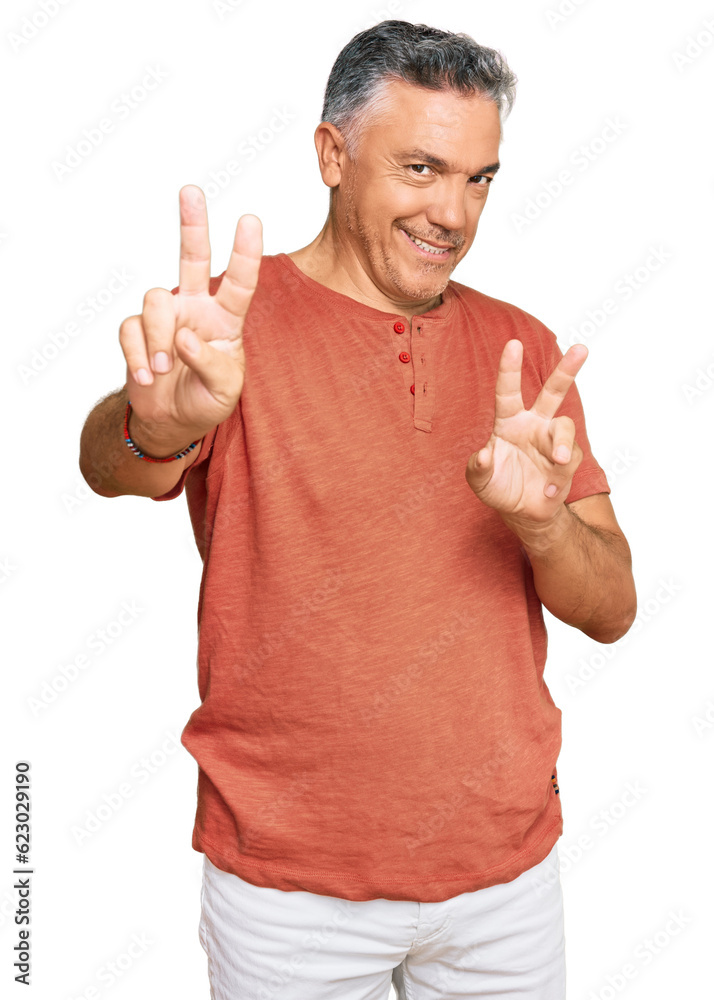 Naklejka premium Handsome middle age man wearing casual clothes smiling looking to the camera showing fingers doing victory sign. number two.