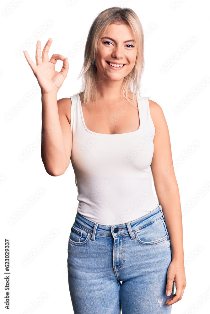 Young beautiful blonde woman wearing casual sleeveless t-shirt smiling positive doing ok sign with hand and fingers. successful expression. Young beautiful blonde woman wearing casual sleeveless t-shirt smiling positive doing ok sign with hand and fingers. successful expression.