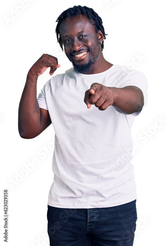 Young african american man with braids wearing casual white tshirt smiling doing talking on the telephone gesture and pointing to you. call me.