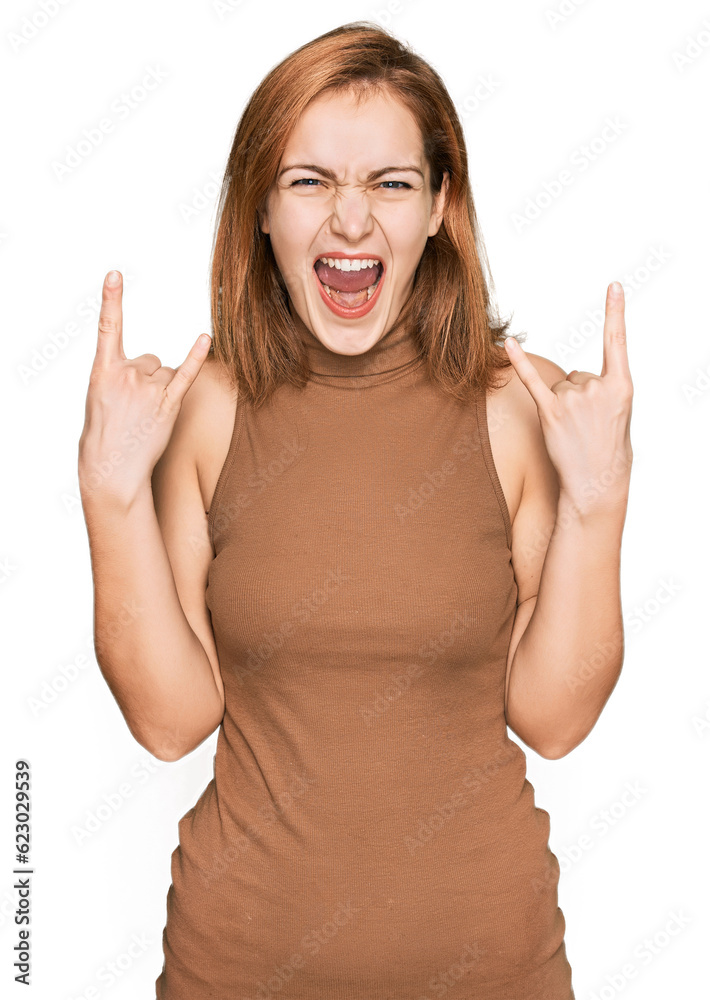 Young caucasian woman wearing casual clothes shouting with crazy expression doing rock symbol with hands up. music star. heavy concept. Young caucasian woman wearing casual clothes shouting with crazy expression doing rock symbol with hands up. music star. heavy concept.