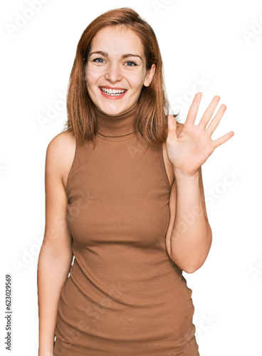 Young caucasian woman wearing casual clothes showing and pointing up with fingers number five while smiling confident and happy.