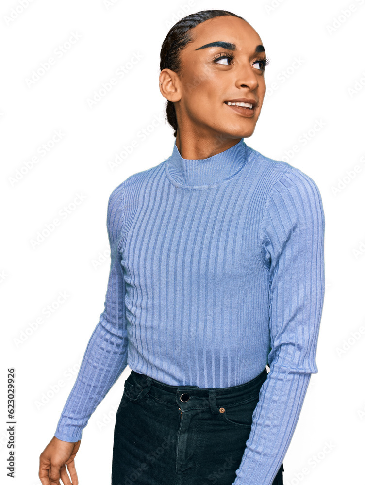Hispanic transgender man wearing make up and long hair wearing casual clothes looking away to side with smile on face, natural expression. laughing confident. Hispanic transgender man wearing make up and long hair wearing casual clothes looking away to side with smile on face, natural expression. laughing confident.