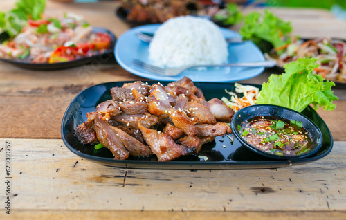 Grilled pork with sweet and sour sauce, Thai papaya salad, fried frog and Thai spicy mixed salad.