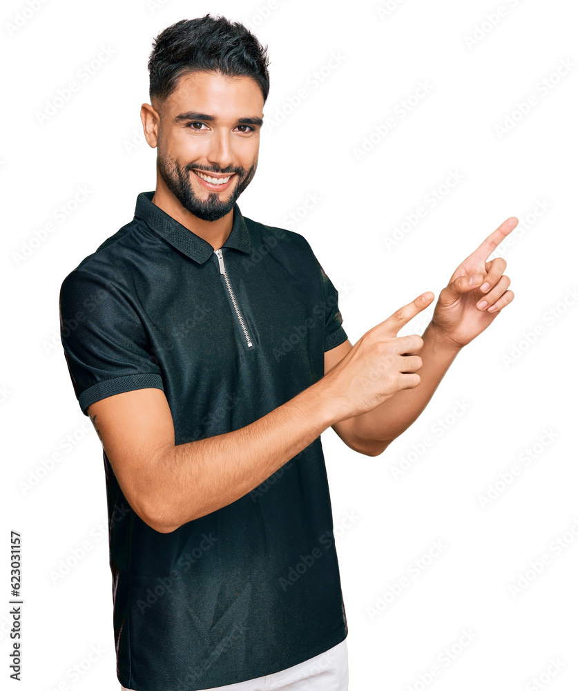 Young man with beard wearing sportswear smiling and looking at the camera pointing with two hands and fingers to the side. Young man with beard wearing sportswear smiling and looking at the camera pointing with two hands and fingers to the side.