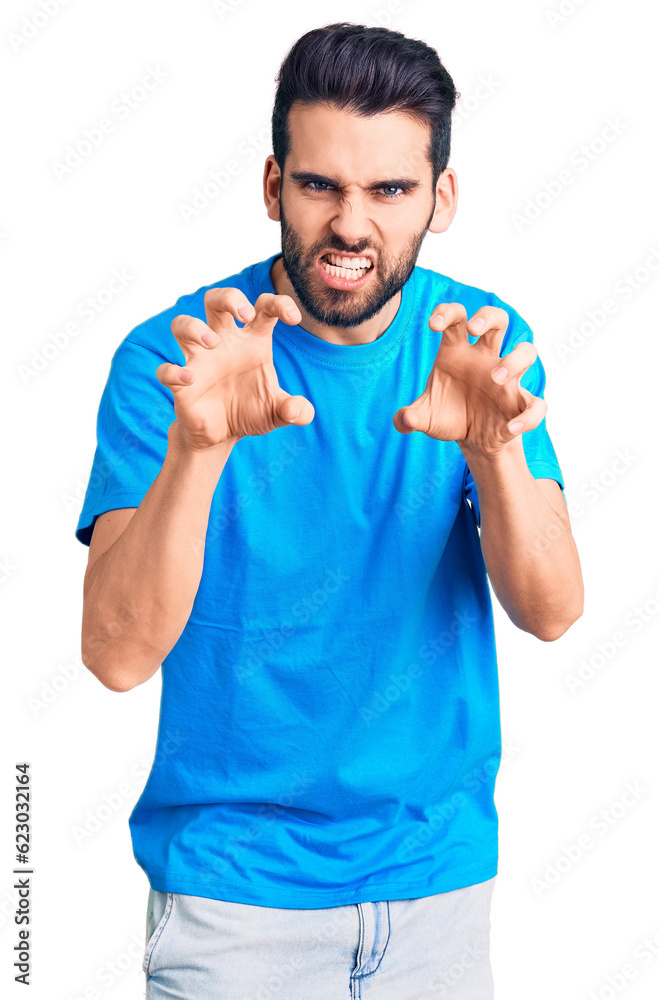 Young handsome man with beard wearing casual t-shirt smiling funny doing claw gesture as cat, aggressive and sexy expression Young handsome man with beard wearing casual t-shirt smiling funny doing claw gesture as cat, aggressive and sexy expression