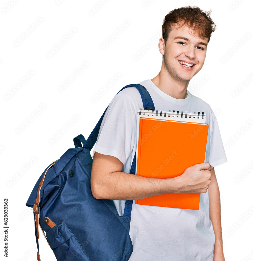Young caucasian man wearing student backpack and holding books looking positive and happy standing and smiling with a confident smile showing teeth Young caucasian man wearing student backpack and holding books looking positive and happy standing and smiling with a confident smile showing teeth