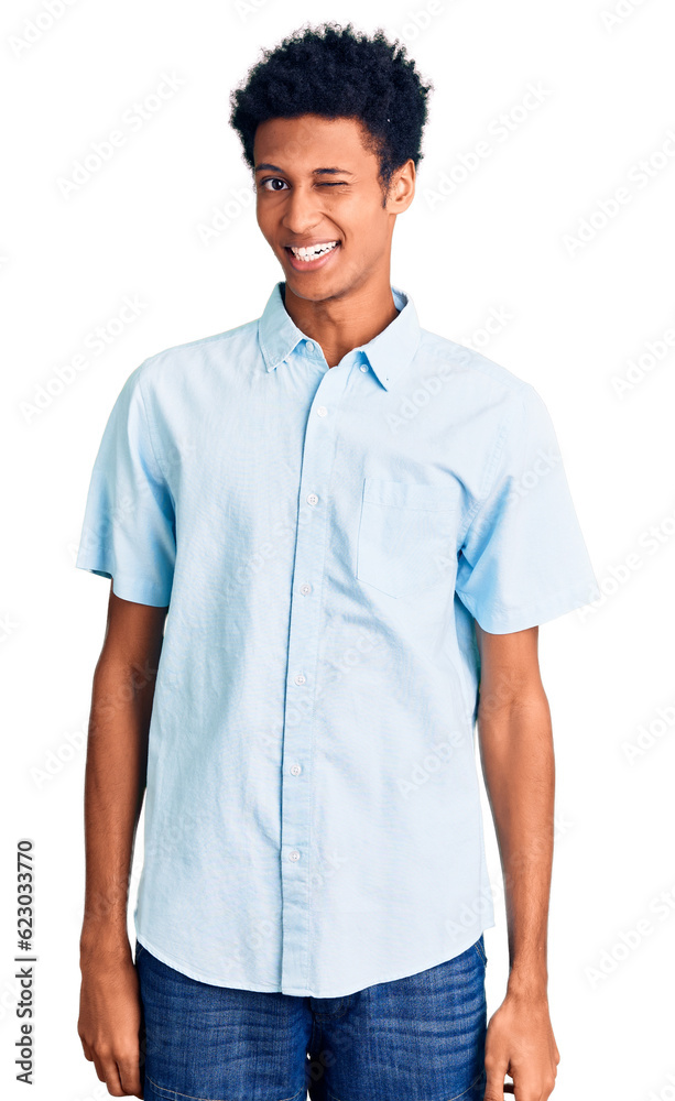 Young african american man wearing casual clothes winking looking at the camera with sexy expression, cheerful and happy face. Young african american man wearing casual clothes winking looking at the camera with sexy expression, cheerful and happy face.
