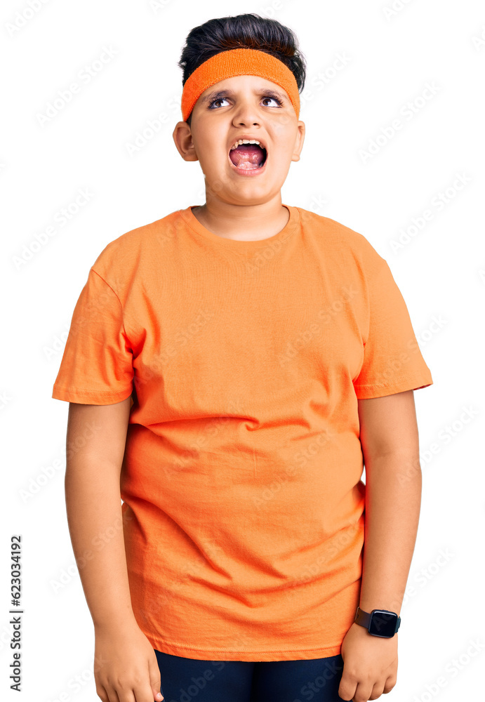 Little boy kid wearing sportswear angry and mad screaming frustrated and furious, shouting with anger. rage and aggressive concept.
