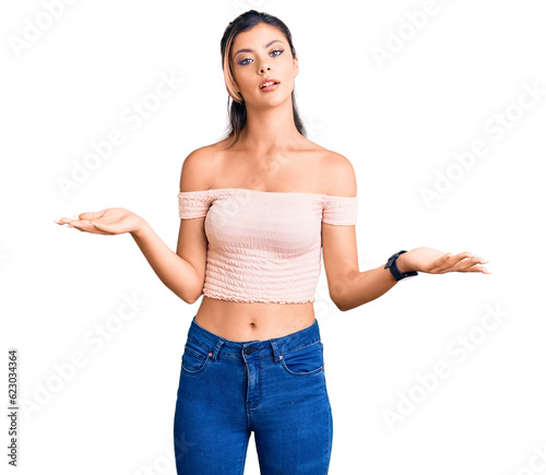 Young beautiful woman wearing casual clothes clueless and confused with open arms, no idea concept. © Krakenimages.com