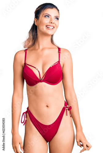 Young beautiful woman wearing bikini looking away to side with smile on face, natural expression. laughing confident. © Krakenimages.com