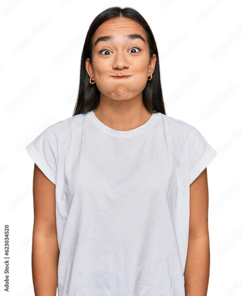 Young asian woman wearing casual white t shirt puffing cheeks with funny face. mouth inflated with air, crazy expression. - obrazy, fototapety, plakaty 