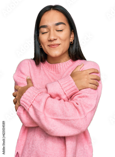 Konstfotografi Young asian woman wearing casual winter sweater hugging oneself happy and positive, smiling confident