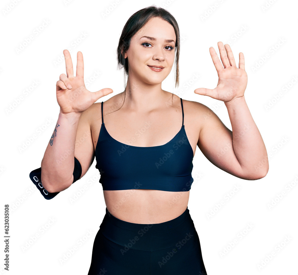 Young hispanic woman wearing sportswear showing and pointing up with fingers number eight while smiling confident and happy. Young hispanic woman wearing sportswear showing and pointing up with fingers number eight while smiling confident and happy.