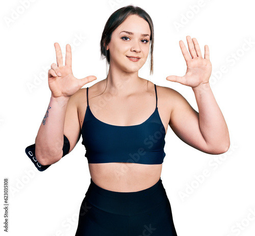 Young hispanic woman wearing sportswear showing and pointing up with fingers number eight while smiling confident and happy.