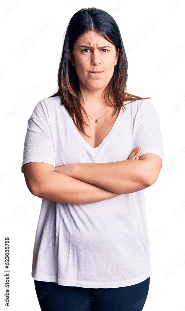 Young beautiful brunette woman wearing casual t-shirt skeptic and nervous, disapproving expression on face with crossed arms. negative person. Young beautiful brunette woman wearing casual t-shirt skeptic and nervous, disapproving expression on face with crossed arms. negative person.