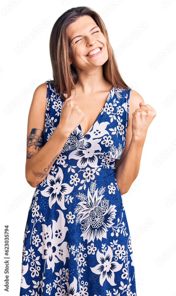 Beautiful caucasian woman wearing summer dress excited for success with arms raised and eyes closed celebrating victory smiling. winner concept. Beautiful caucasian woman wearing summer dress excited for success with arms raised and eyes closed celebrating victory smiling. winner concept.