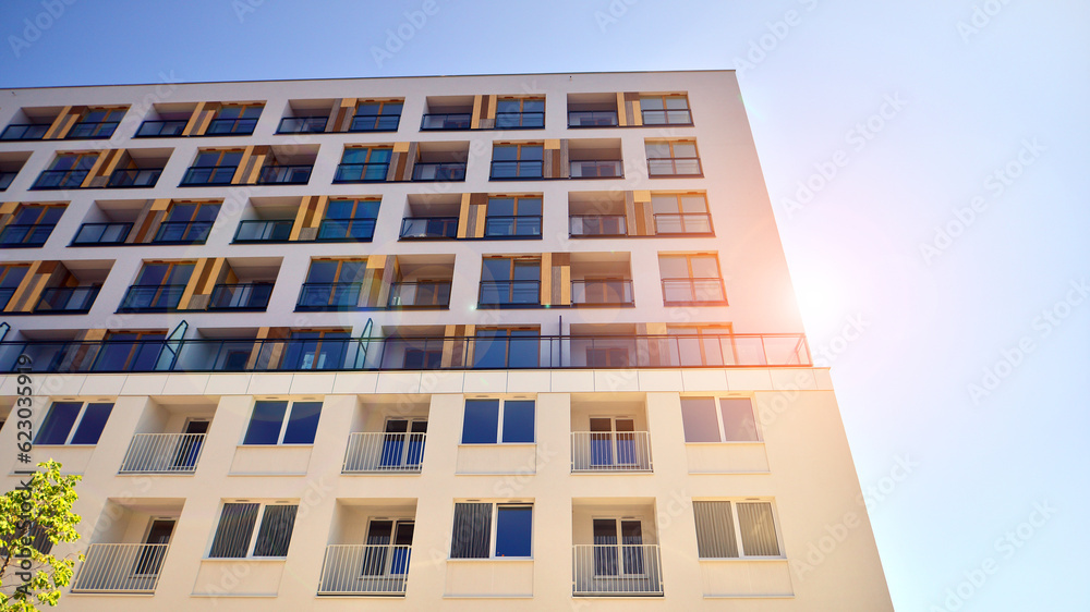 Contemporary residential building exterior in the daylight. Modern apartment buildings on a sunny day with a blue sky. Facade of a modern apartment building. 