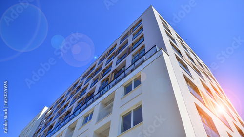 Contemporary residential building exterior in the daylight. Modern apartment buildings on a sunny day with a blue sky. Facade of a modern apartment building.  © Grand Warszawski